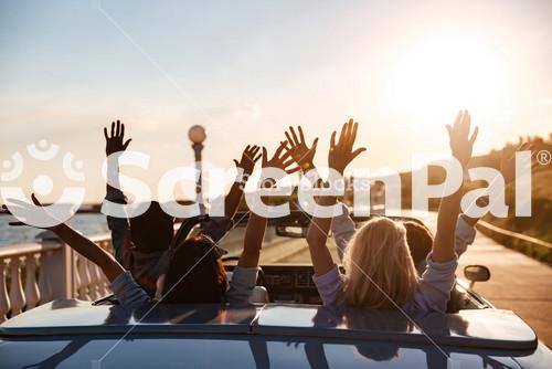 Friends Enjoying Sunset Drive In A Convertible